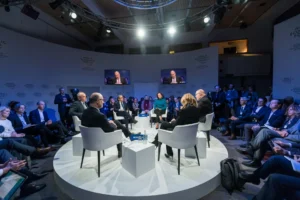 Foro empresarial con participantes en mesa de diálogo